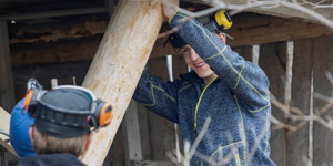 Håndverker setter på plass stolpe i et skjeltverksnaust