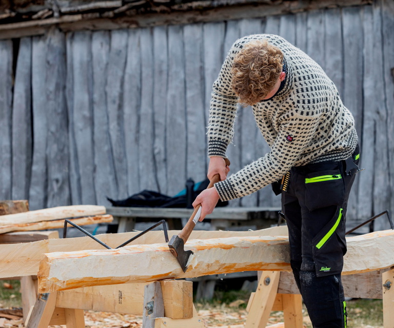 Ungdommene lærer utrolig fort, forteller Jan Kleine. Fra å stå feil med øksa første dag, til å bruke hele kroppen og se nye måter å forme treet på allerede dag to. Foto: Marlen L Hagen, Bygg og Bevar