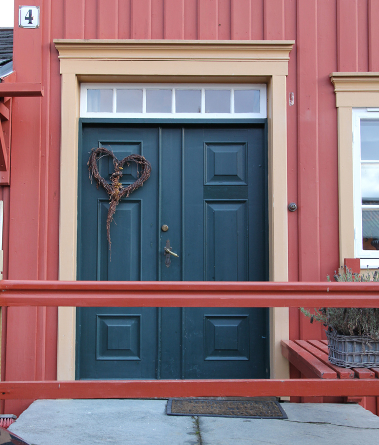 Koboltblå dør med okergul omramming, hvite vinduer og rød kledning. Røros. Foto: Christel Wigen Grøndahl, Bygg og Bevar