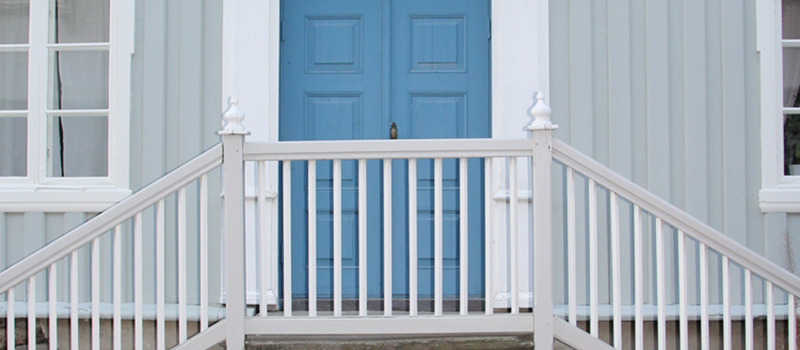 Dør i klar ultramarin, hvit omramming og lys ultramarin vegg. Foto: Christel Wigen Grøndahl, Bygg og Bevar