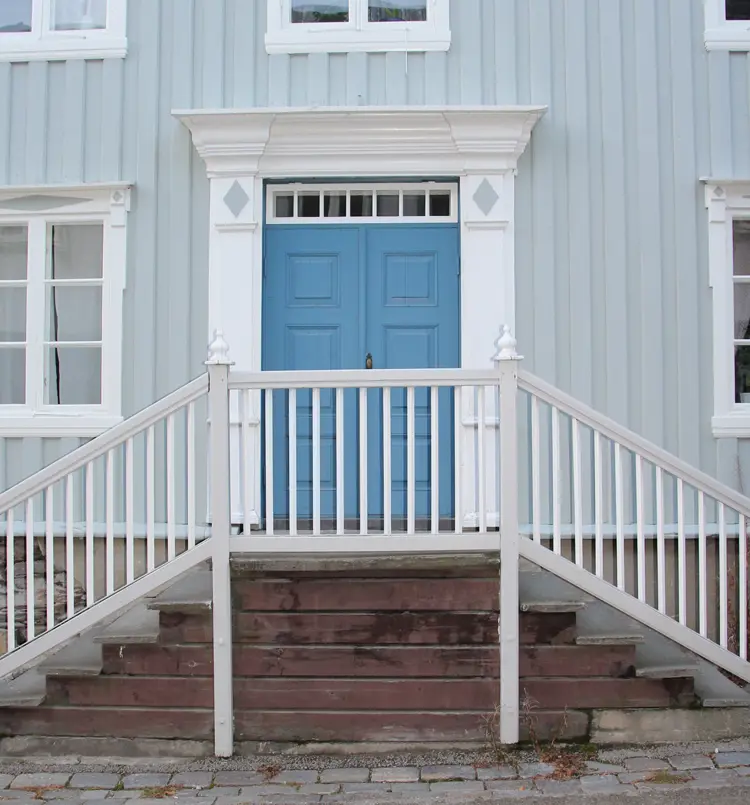 Dør i klar ultramarin, hvit omramming og lys ultramarin vegg. Foto: Christel Wigen Grøndahl, Bygg og Bevar