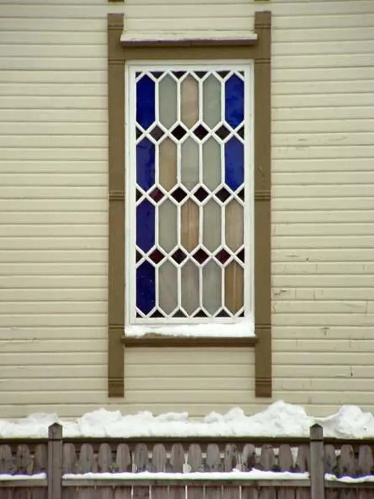 Vindu med felter av farget glass i dragestil . Foto: Ivar Ole Iversen, Byggeskikksenteret i Flekkefjord