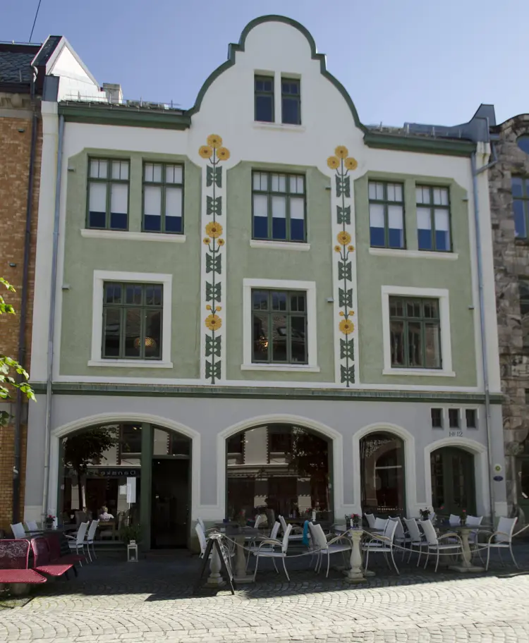 Fasadene i Kongens gate var de første som ble vernet i Ålesund. I ens gate 12, til venstrdenne gata kan en også følge ulike måter å tenke bevaring gjennom de siste førti åra. Konge, er fredet og dermed bevart i sin opprinnelige skikkelse. Foto: Jugendstilsenteret