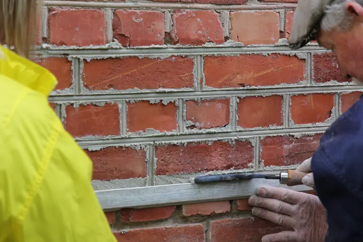 Det kan være praktisk å være to når man skal dra fugjernet langs et rettholt. Foto: Christel Wigen Grøndahl, Bygg og Bevar