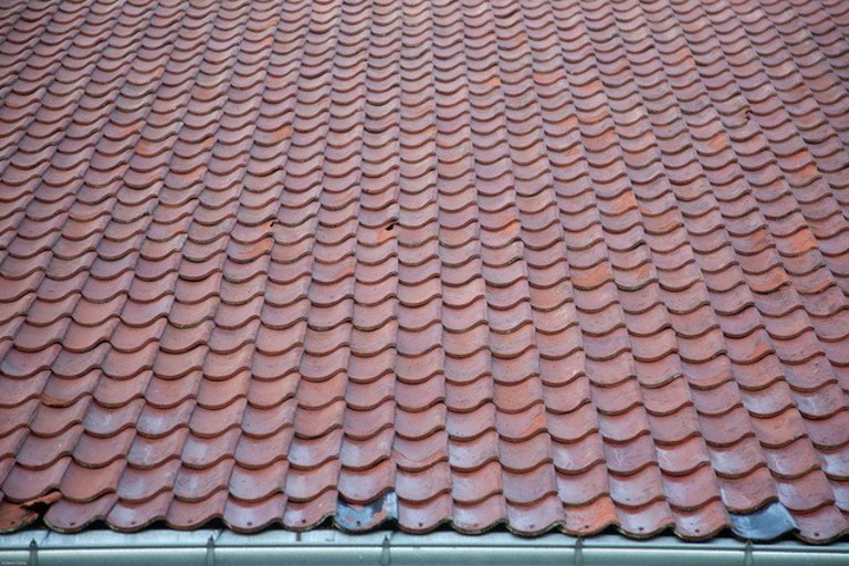 Tegltak er holdbart med riktig stell. Detalj av vaska tak som avslører skadd stein. Foto: Kolbein Dahle