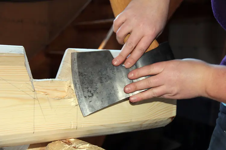 Hege Laugerud finpusser passformen med øksa. Foto: Christer Stenby