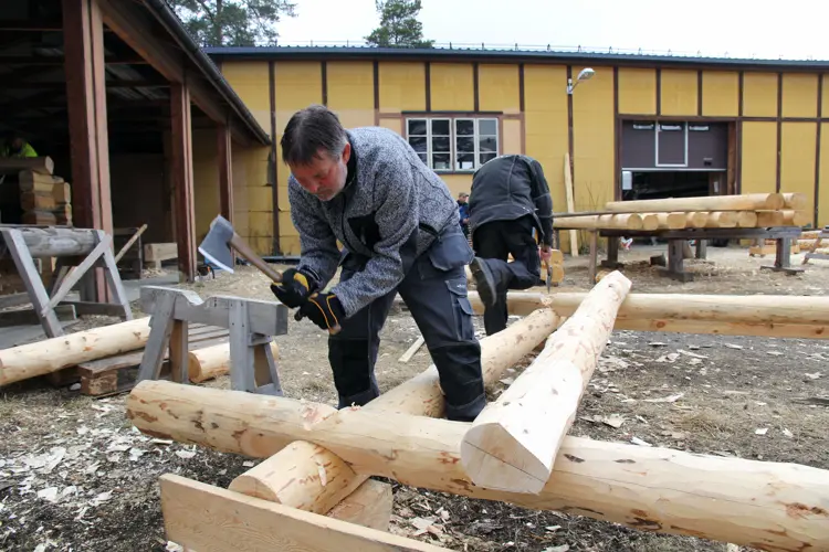 Dette er Dag Kjensli som hugger et raulandslaft på en liten stue som bygges opp på laftekurset. Ikke håndverker, men en som syntes det var spennende og interessant å lære mer om lafting. Foto: Christer Stenby