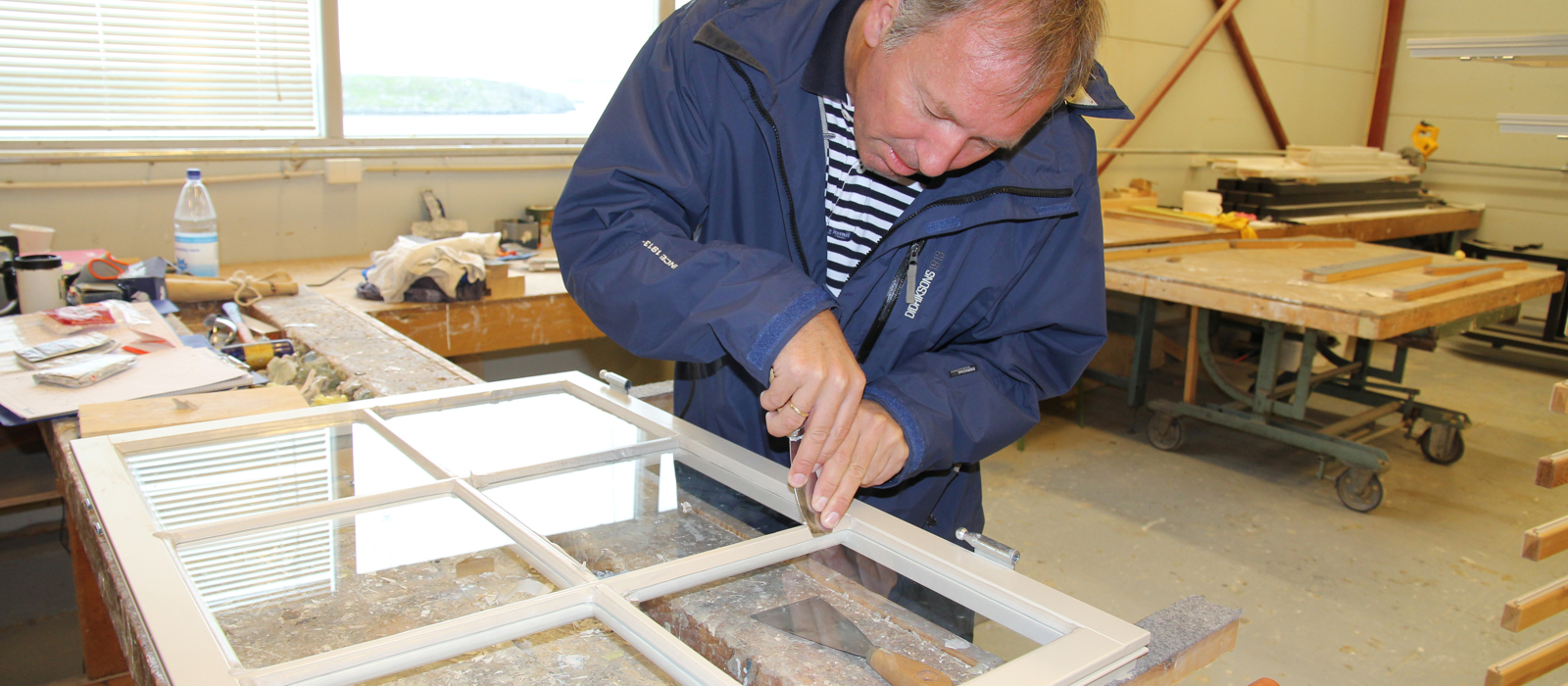 Ole Olsen ser om han husker gamle kunster. Kitting av vinduer gjøres med linoljekitt og vinduene er eksakte kopier. Foto: Christel Wigen Grøndahl, Bygg og Bevar 
