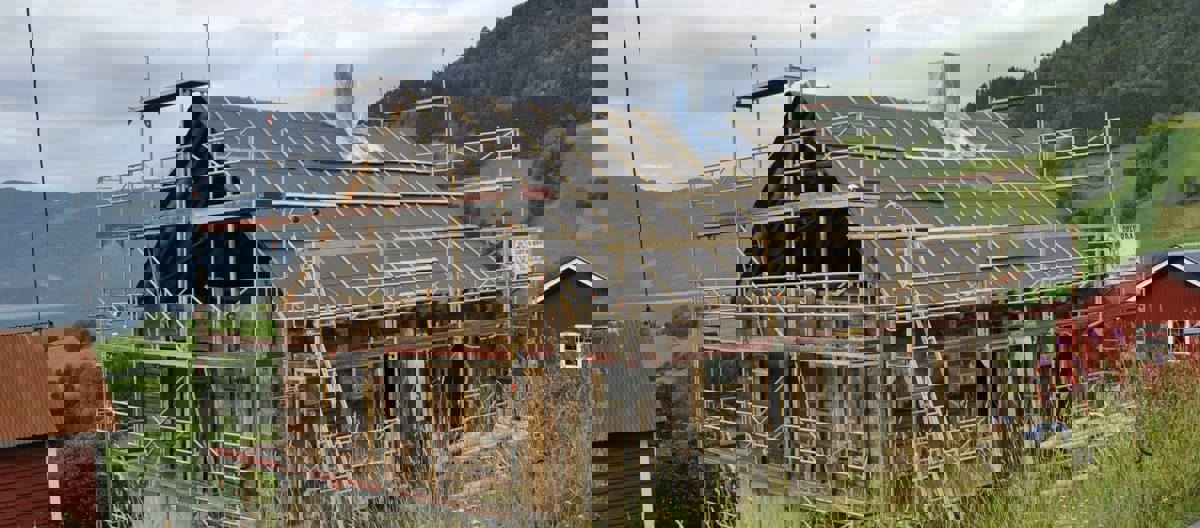 Takkonstruksjonen er bygget opp igjen, bindingsverket i gavlen er fjernet og kledningen er fjernet. Taket er vindtettet. Foto: Solvorn Laft og Bygg