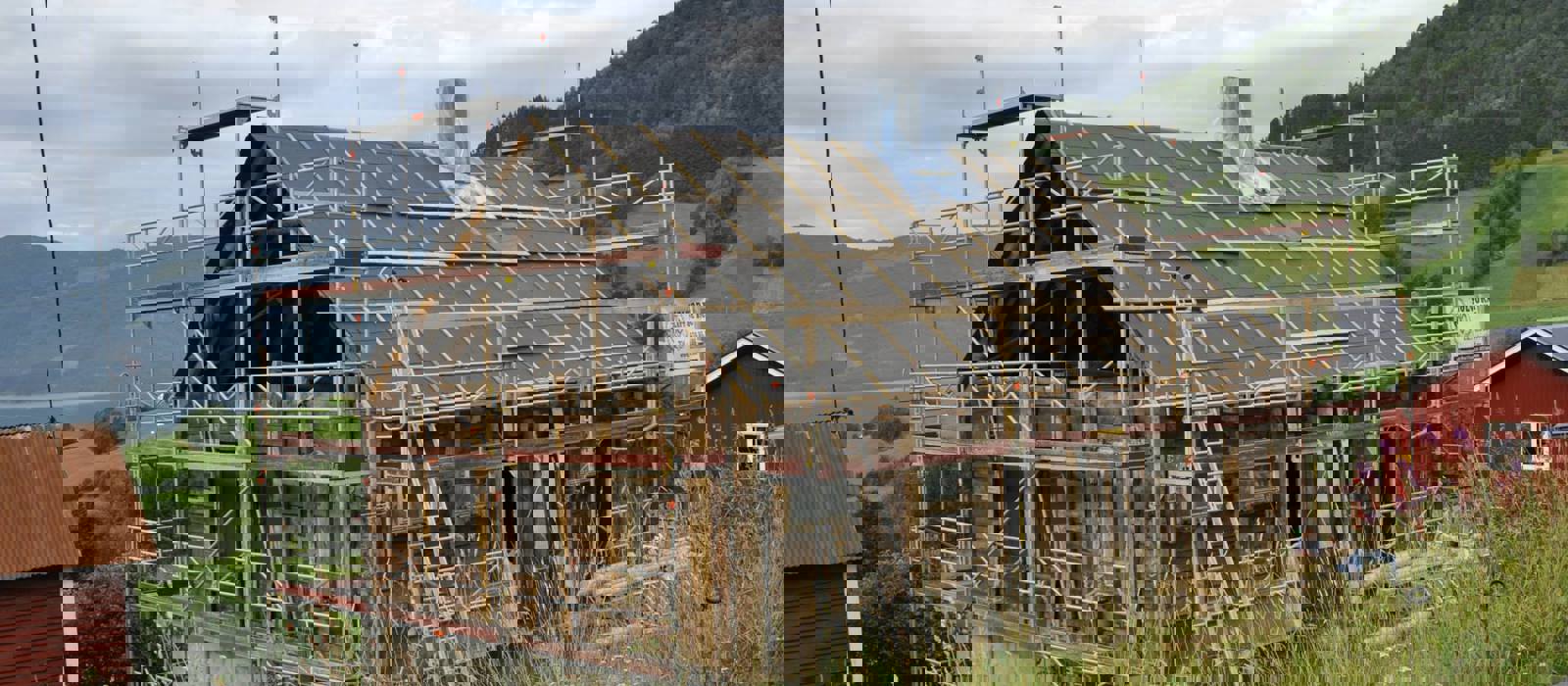 Takkonstruksjonen er bygget opp igjen, bindingsverket i gavlen er fjernet og kledningen er fjernet. Taket er vindtettet. Foto: Solvorn Laft og Bygg