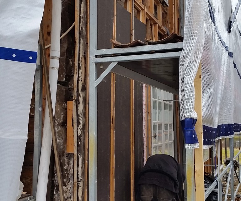 Montering av asfaltplater. Disse er trukket noe inn på stenderverke for å sikre tilstrekkelig lufting mot kledningen. Foto: Ove Losnegård