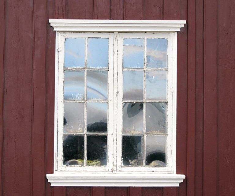 Et originalt vindu med slanke sprosser og vinkelbeslag. Her kan bare det ene vindusfaget åpnes. Legg merke til det vakre spillet i det håndlagede glasset. Foto: Norske Hjem