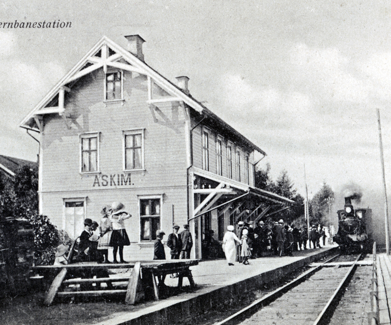 Stasjonsbygninger i siste halvdel av 1800-tallet ble gjerne oppført i sveitserstil. Parti fra Askim stasjon, oppført I 1882, med damplokmotiv.