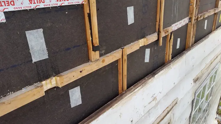 Asfaltplatene er montert som vindtetting. Celluloseisolasjon er innblåst og kledning monteres med god lufting. Foto: Ove Losnegård