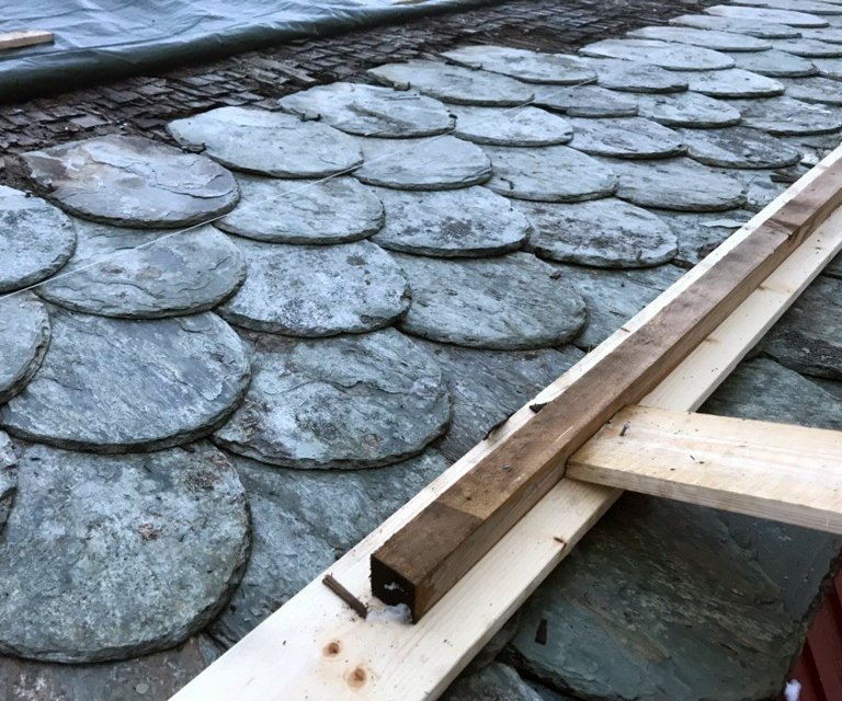 Skiferen festes direkte i troa med klipt spiker. Hakk på siden av dråpeskiferen er for innfestingen. Ingen hull blir eksponert når skiferen i raden over legges på plass. Foto: Karl Prytz/Bygningsvernprosjektet