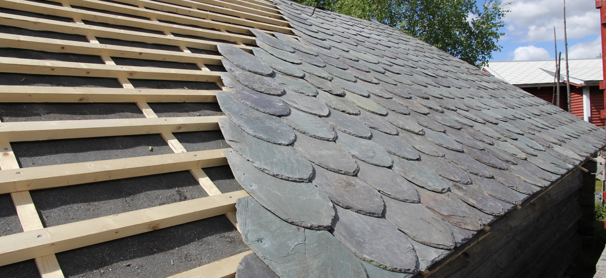 Skifertekking i Valdres. Denne lappskiferen kjennetegnes av en spiss i fremkant. Foto: Bygg og Bevar