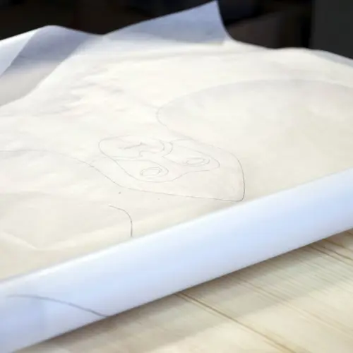 Treskjærer Jens Kåre Holen har kopiert ornamentikken på det opprinnelige gildebordet som er magasinert på Maihaugen. Nå skjæres en kopi - som skal brukes på fest og som skal beskytte deltakerne mot Mara. Foto: Bygg og Bevar