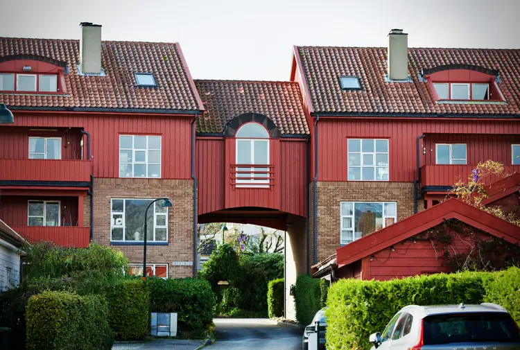 Rekkehus med røde fasader og grønne forhager. Den røde og grønne fargen er en del av fargepaletten som gjelder for feltet. Foto. Lise Bjelland